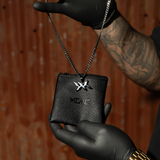 IAC leather pouch packaging for DNA Strand pendant necklace, shown in hand