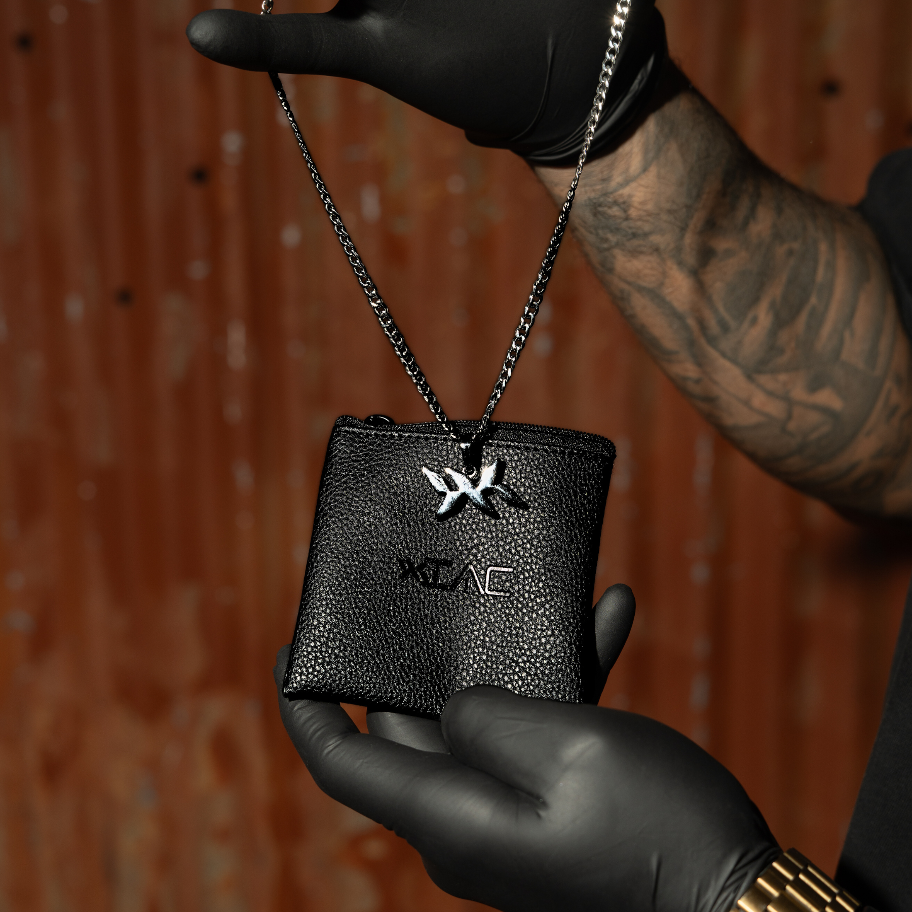 IAC leather pouch packaging for DNA Strand pendant necklace, shown in hand